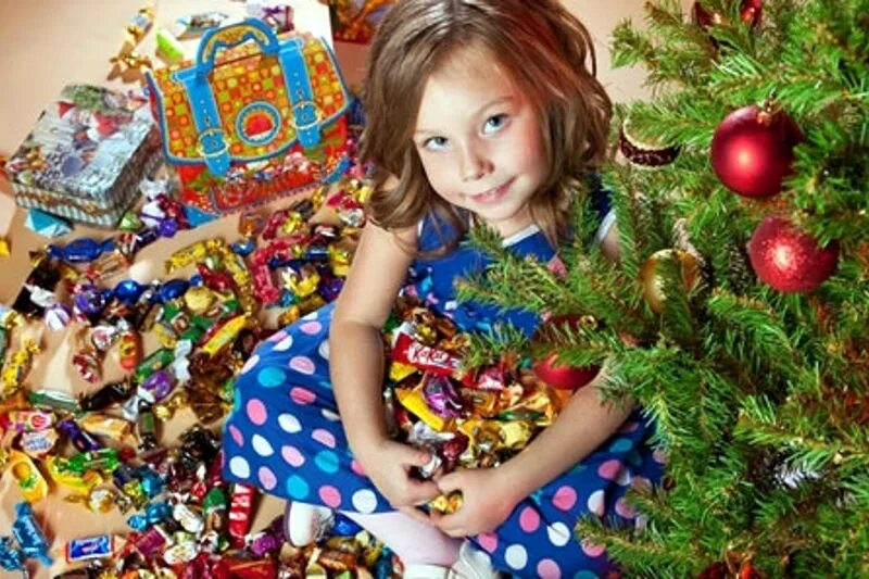 Подарок ребенку россия. Новогодние подарки сладкие под елкой. Сладости для детей на новый год. Дети под елкой с подарками конфетными. Ребенок со сладким подарком на новый год.