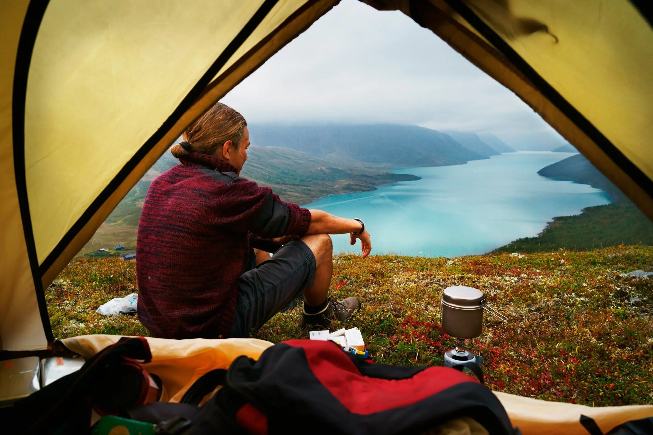 Свободная поездка. Уют в туристической палатке. Уют в палатке в походе. Люди в палатке. Палатка у озера.