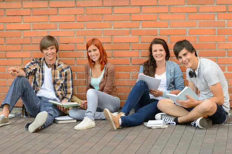 Студент на земле сидит. Студент сидит в телефоне. Фото на фоне кирпичной стены для 3 друзей. Студенты сидят взрослые стоят.