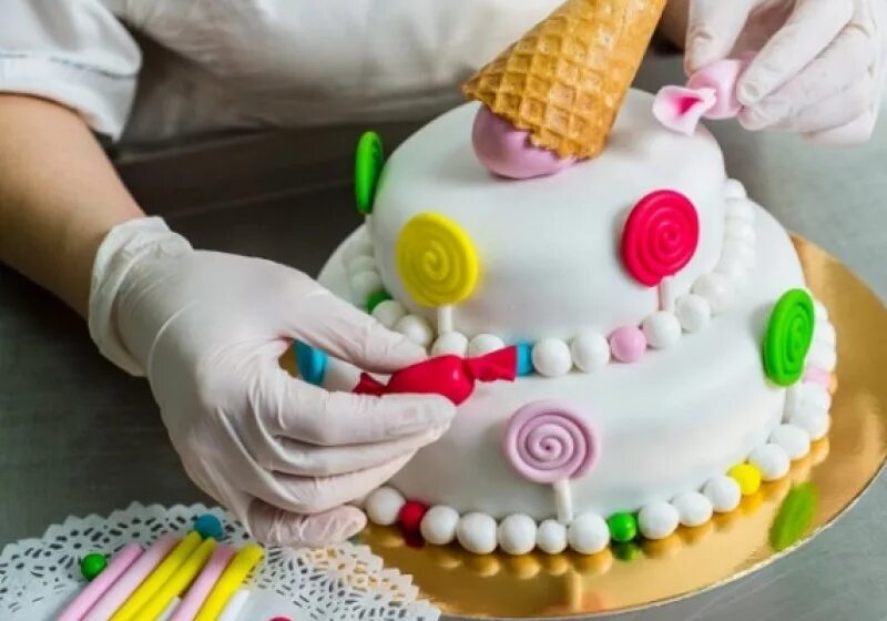 Кондитер украшает торты. Печь торт. Украшение тортов кондитерскими украшениями. Украшение торта мастикой. Торты ручной готовки.