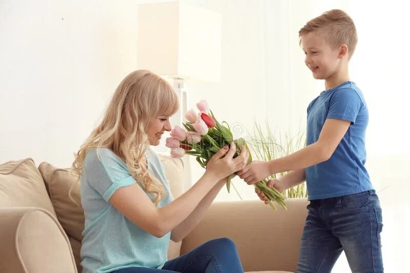 Мальчик дарит букет маме. Мальчик дарит тюльпаны маме. Ребенок дарит цветы маме. Ребенок дарит маме тюльпаны.