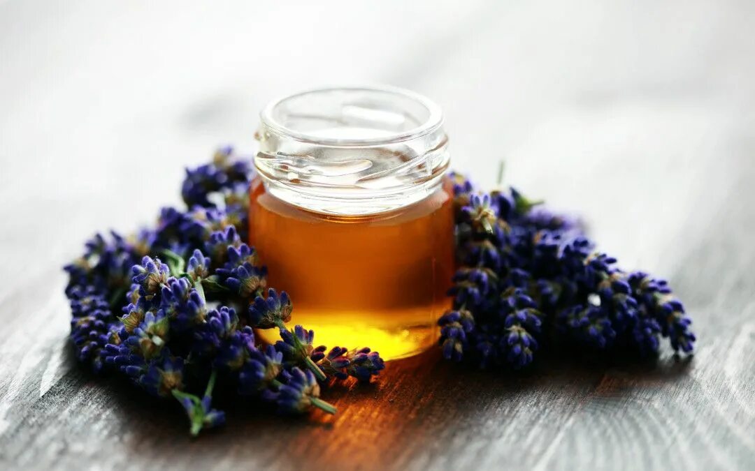 Heather Honey in a Glass Jar and a Bunch of Forest Heather Flowers on a White Ta