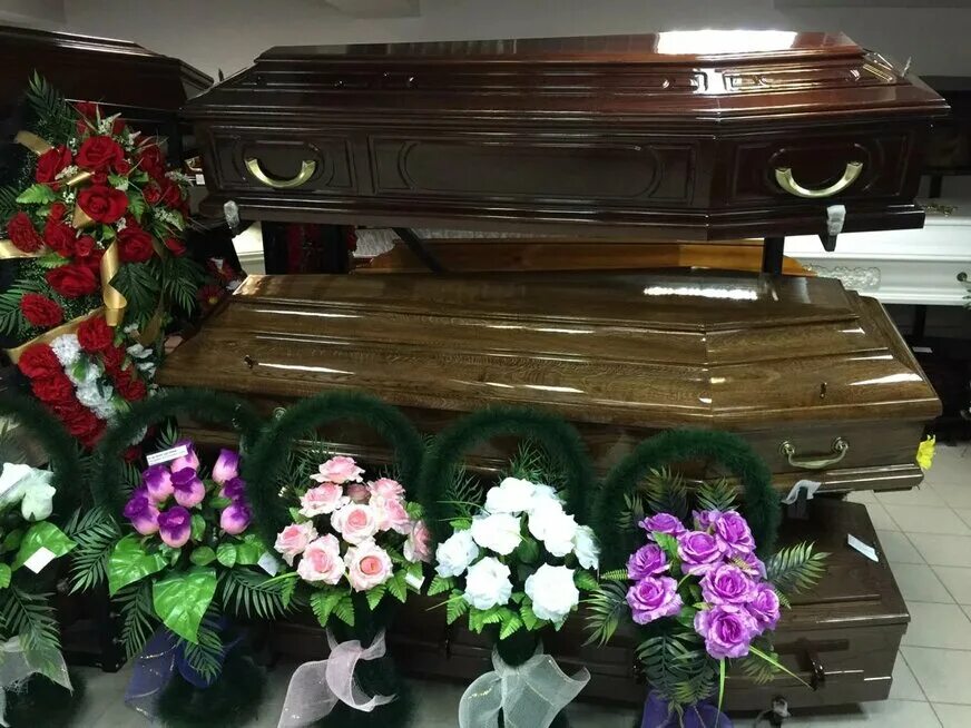 Зал в ритуальных услуг гробы. Похоронное бюро интерьер. Венки на могилу. Похоронное бюро похороны. Ритуальные услуги.