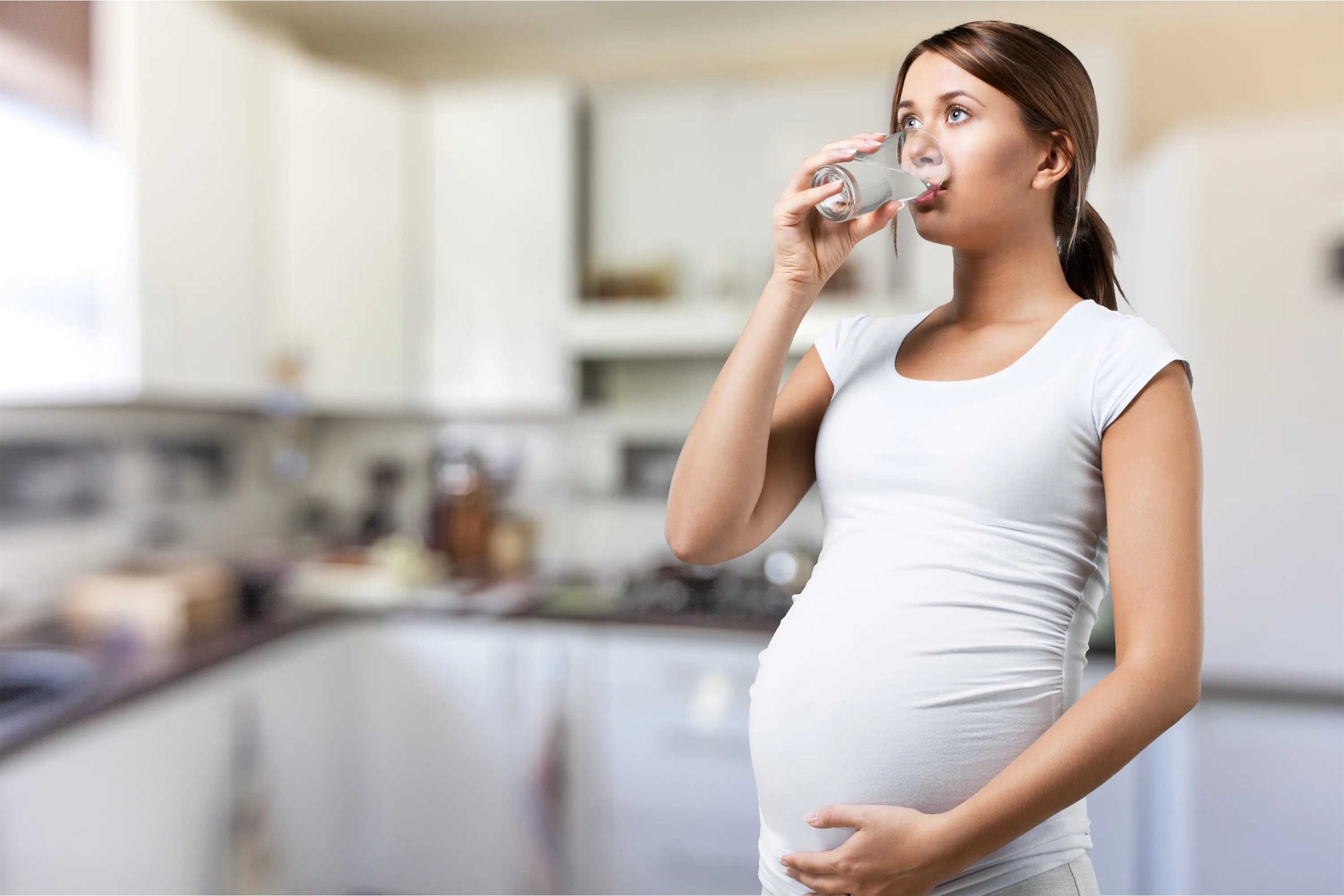 Питье беременных. Женщина пьет воду.