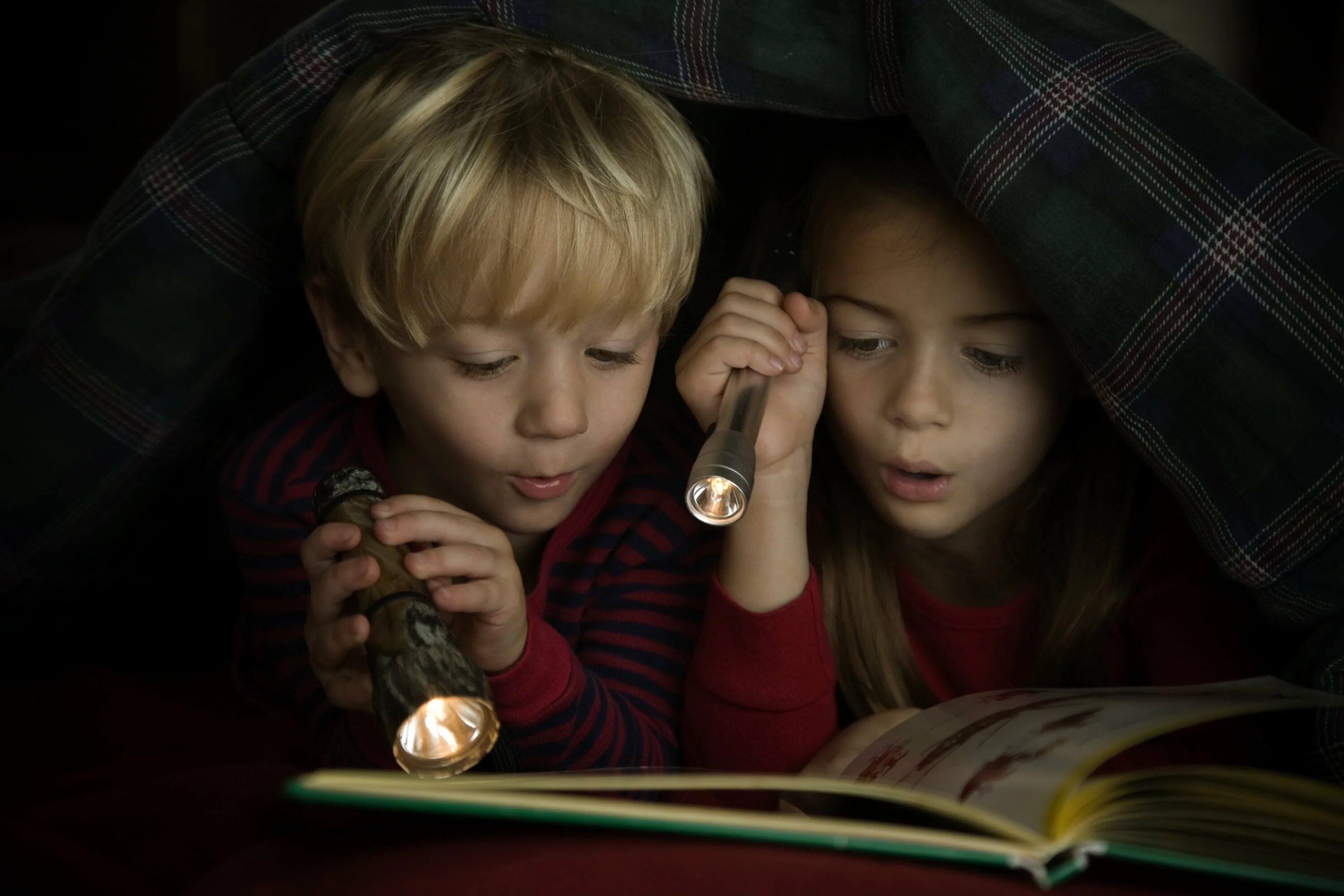 Читаем бай. Чтение в темноте. Ребенок с фонариком в темноте. Чтение под одеялом с фонариком. Чтение книги в темноте.