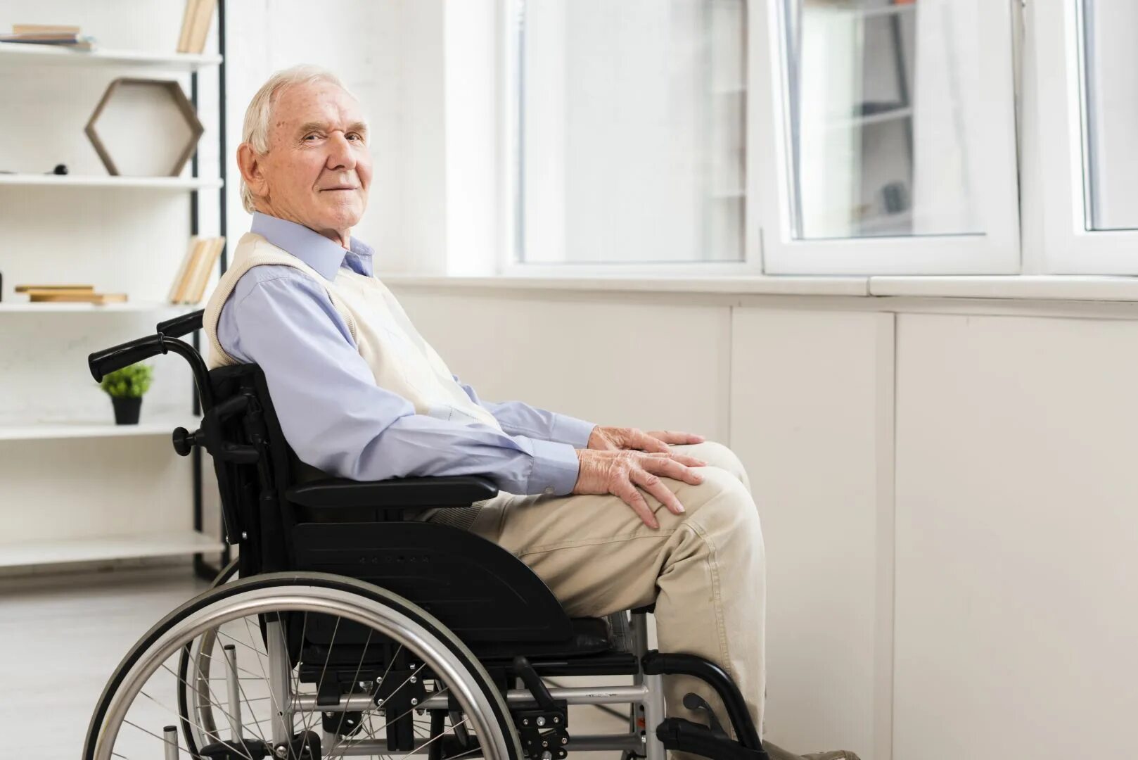 В скромно обставленном кабинете сидел пожилой человек. Пожилой мужчина в инвалидной коляске. Коляска для инвалидов. Инвалид старик в магазине. Фото пожилого человека в инвалидном кресле.