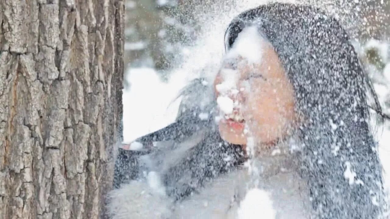 Снежком в глаз. Лицо девушки в снегу. Девушка умывает лицо снегом.