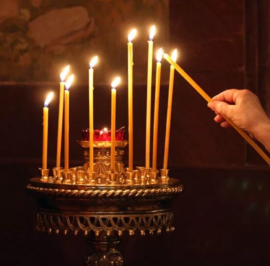 православный храм. красивая женщина в церкви. зажженная свеча в церкви. мужчина со свечами в храме. женщине поставили свечку.