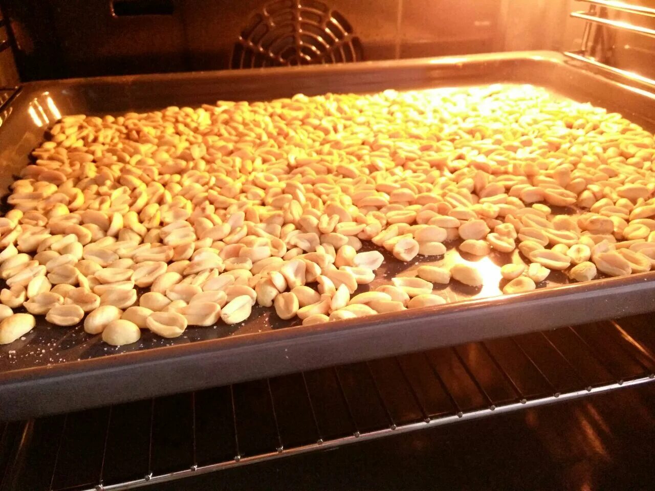 При какой температуре жарить арахис в духовке. Арахис в духовке. Бобы арахиса жареные. Арахис без скорлупы. Сушка орехов в духовке.