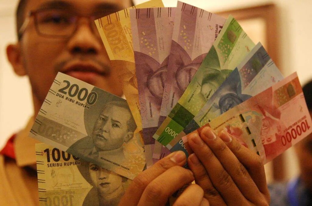 Сколько денег на бали. Деньги Индонезии. Индонезийские деньги в руках. Банкноты Бали. Деньги Бали.