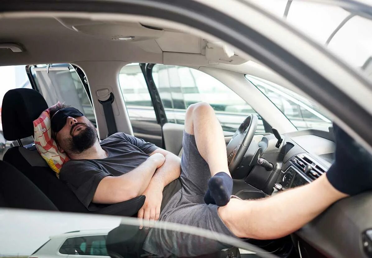 спать в машине. человек спит в машине. сон в машине. мужчина спит в машине. ночевка в багажнике машины.