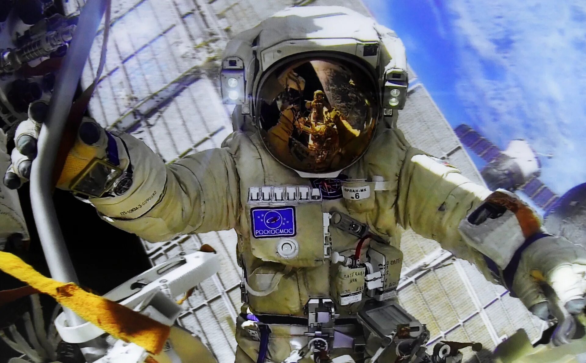 Выход российских космонавтов в открытый космос. Космонавт Роскосмоса в открытом космосе. Космонавты на станции.