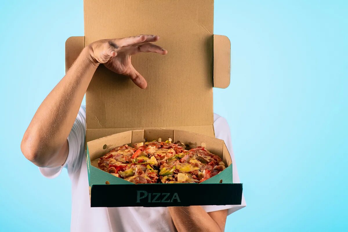 Американцы пицца. Забирает пиццу. Держит коробку пиццы.