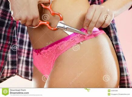 Woman taking off her panties, holding scissors in hand cutting underwear. 