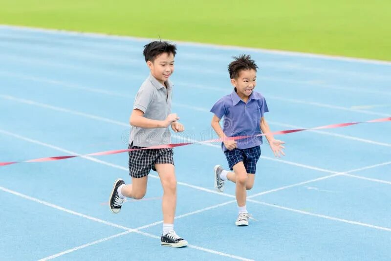 Азиатский мальчик бежит. Мальчик бегает по стадиону. Бегущий парень Азиат. Мальчик в спортивном костюме бегает на стадионе.