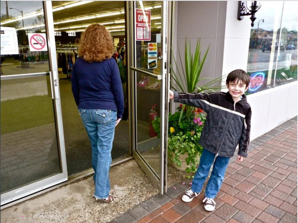 Such situation. Человек придерживает дверь. Мальчик открывает дверь. Заходит в магазин. Человек открывает дверь.