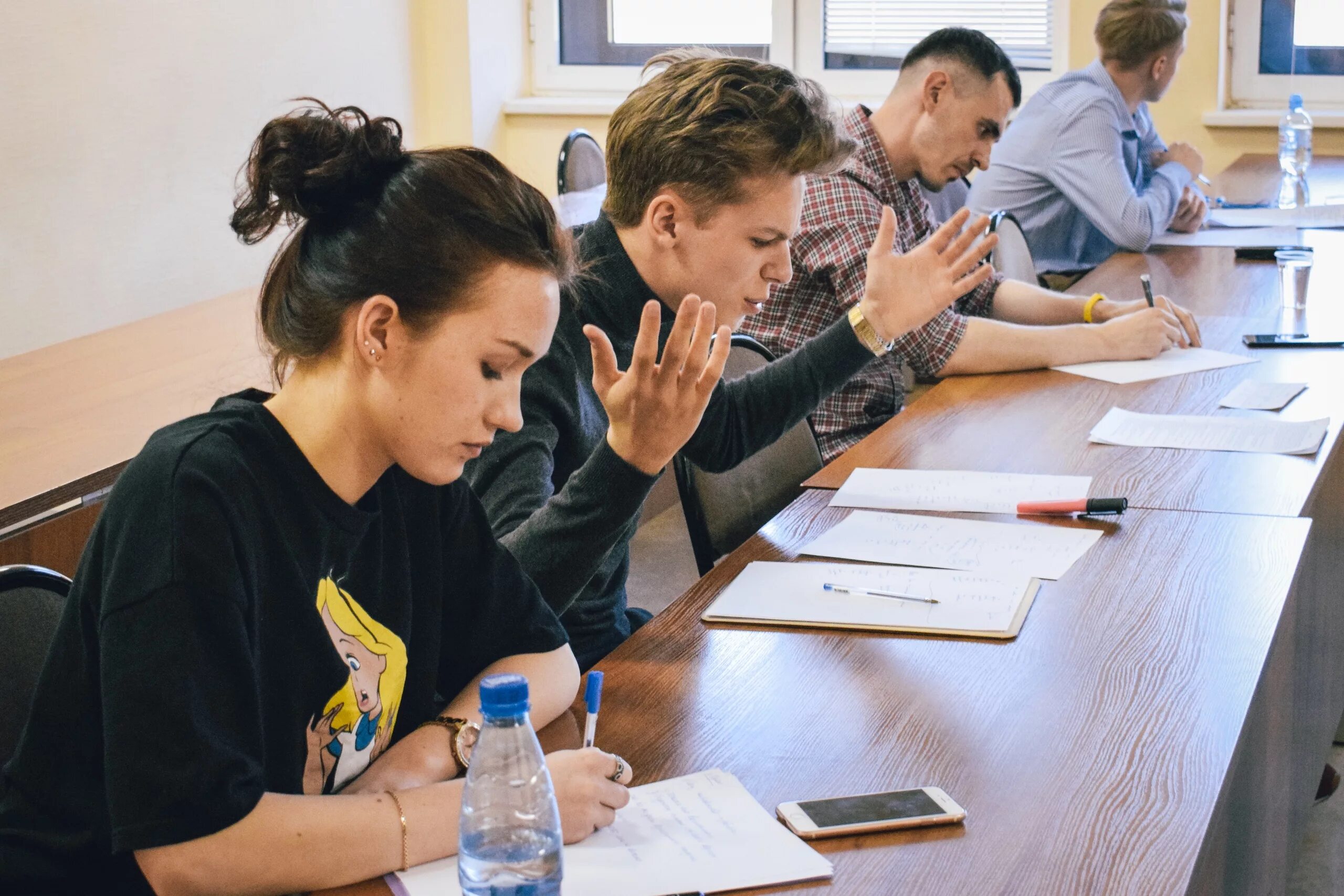 Современная аудитория со студентами. В аудитории началась дискуссия. Преподаватель в аудитории. Дискуссия в школе. Лекция в университете.