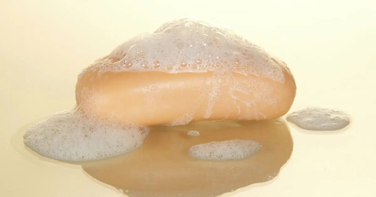 Piece of soap. Мыло на бежевом фоне. кусок мыла с пеной сверху. soap оранж цвет. кусочек мыла в качестве слабительного.
