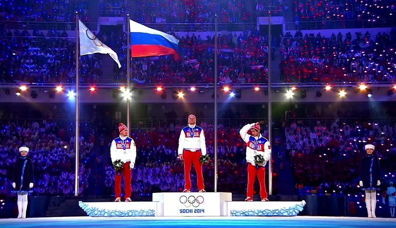 Спортсмен с флагом. Спортсмены на пьедестале. Пьедестал Олимпийских игр. Исполнение гимна России на Олимпиаде.