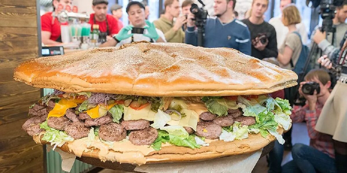 Самый большой бургер. Огромный бутерброд. Самый большой бутерброд. Самый большой сэндвич. Самые большие питания