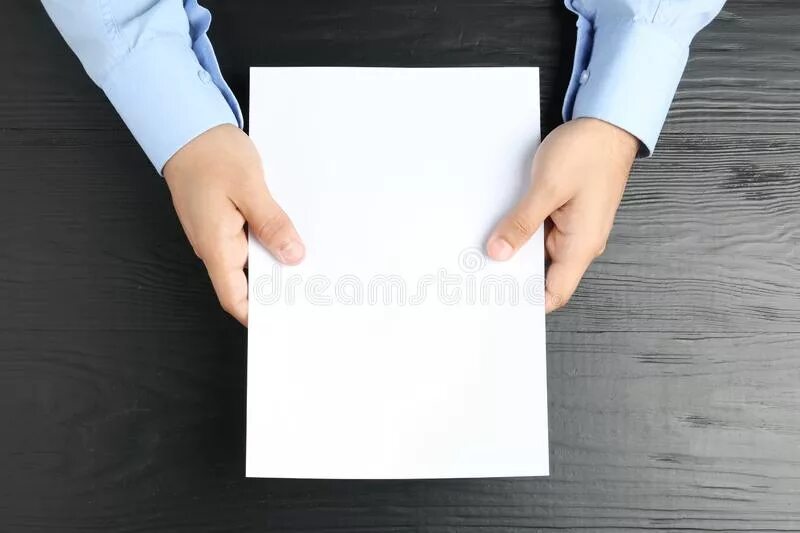 Над бумажным над листом. Складывает листок бумаги. Лист бумаги сверху. Листок бумаги на столе. Держит лист бумаги на столе.