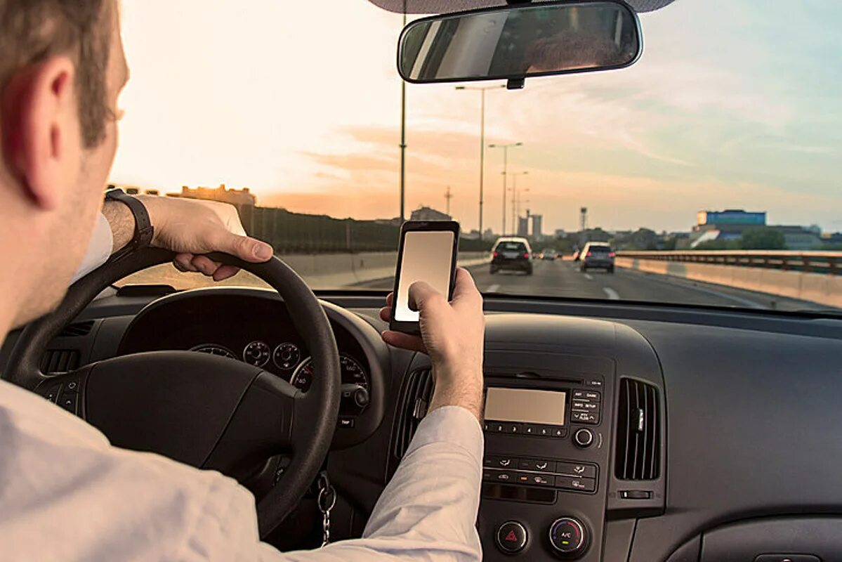 During driving. Водитель с телефоном. Парень за рулем. Водитель с телефоном за рулем. Отвлекать водителя.