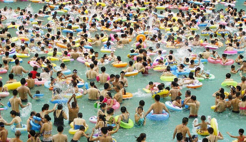 куча народу на пляже. пляж в китае. в воде много народу. в воде много народу. китайский пляж.