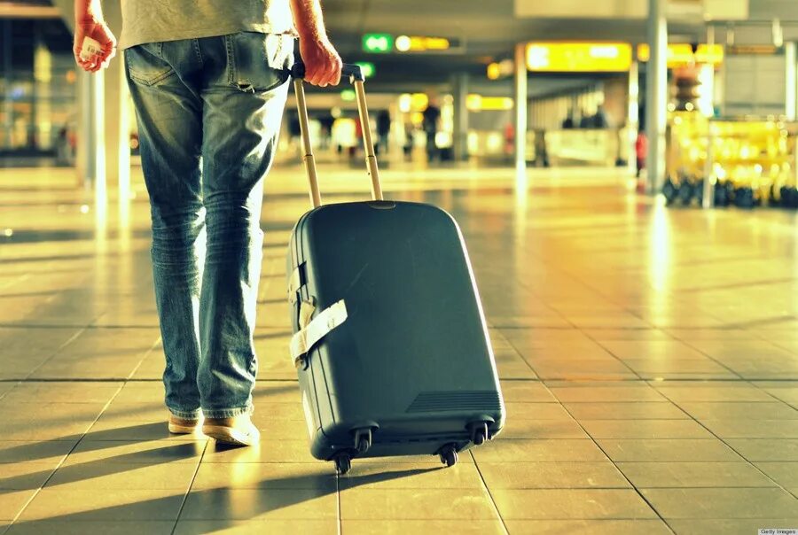 Уезжать ли за границу. Человек с чемоданом. Мужчина с чемоданом в аэропорту. Парень с чемоданом в аэропорту. Человек с багажом.