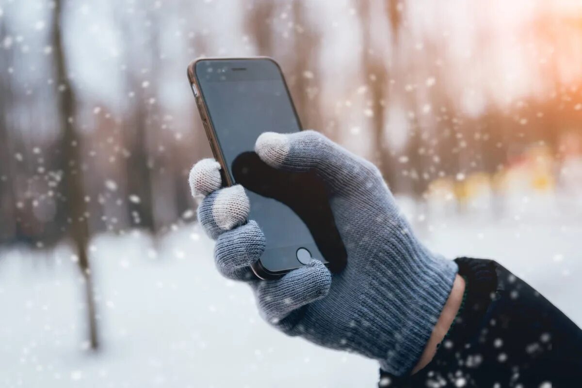 Смартфон на холоде. Телефон на морозе. Телефон в руке зима. Человек на морозе с телефоном. Телефон выключается морозе