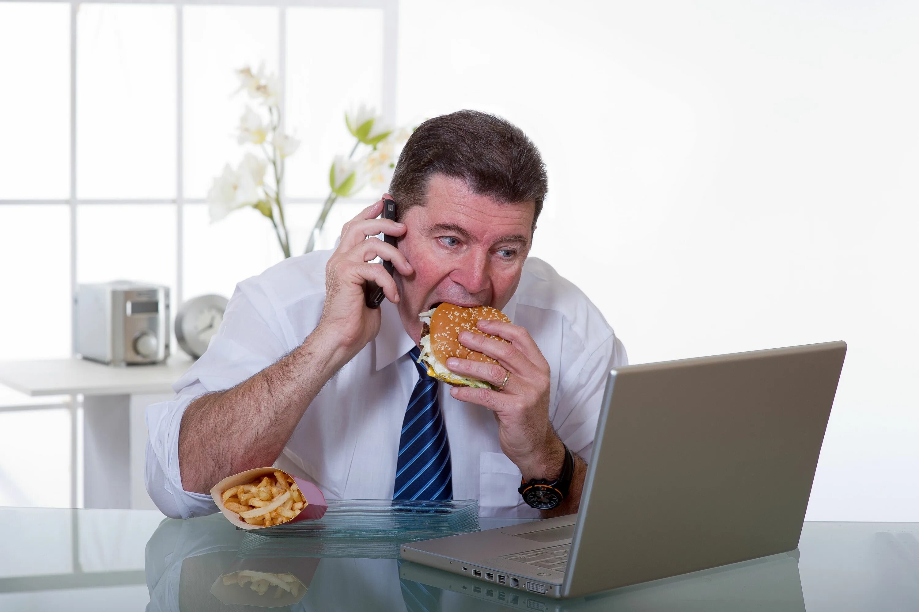 Разговоры во время еды. Человек с едой за компьютером. Питание на работе. Толстый человек в офисе.