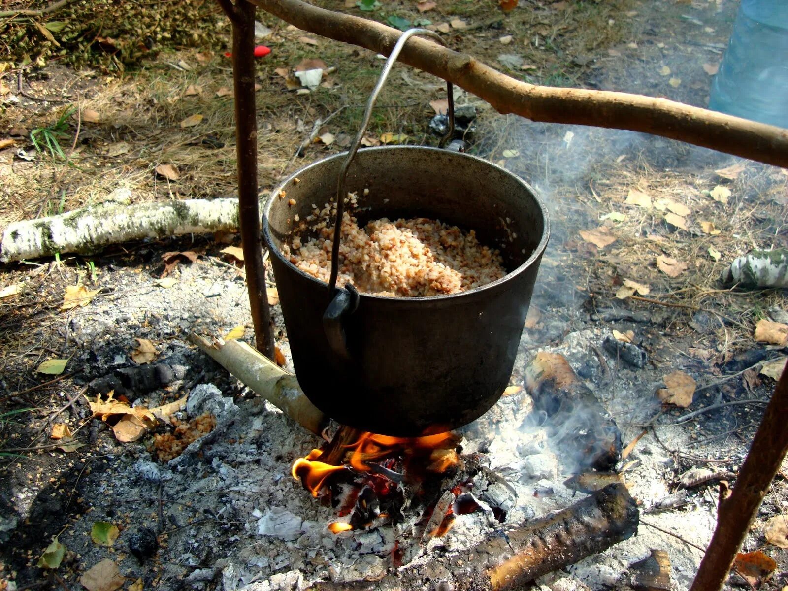 Тушенка на природе. Макароны с тушенкой на костре. Банка тушенки на костре. Котелок на костре. Тушенка с макаронами в походе на костре.