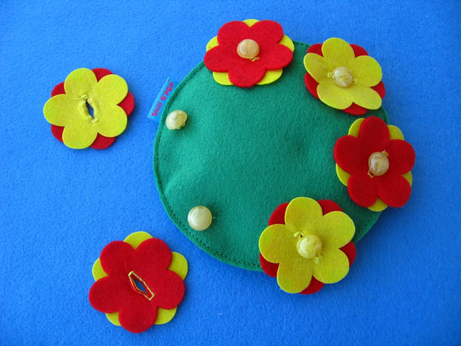 Игрушка из фетра с пуговицами. Тренажер для застегивания пуговиц. Пособие пуговицы. Развивашка с пуговицами. Цветочная полянка из фетра на пуговицах.