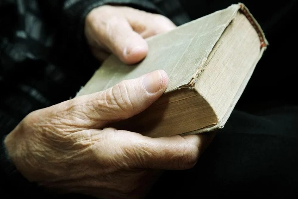 Старая книга в руках. Крупный план книга в руках. Человек с библией. Старая книга в руках. Старинная книжка в женских руках.
