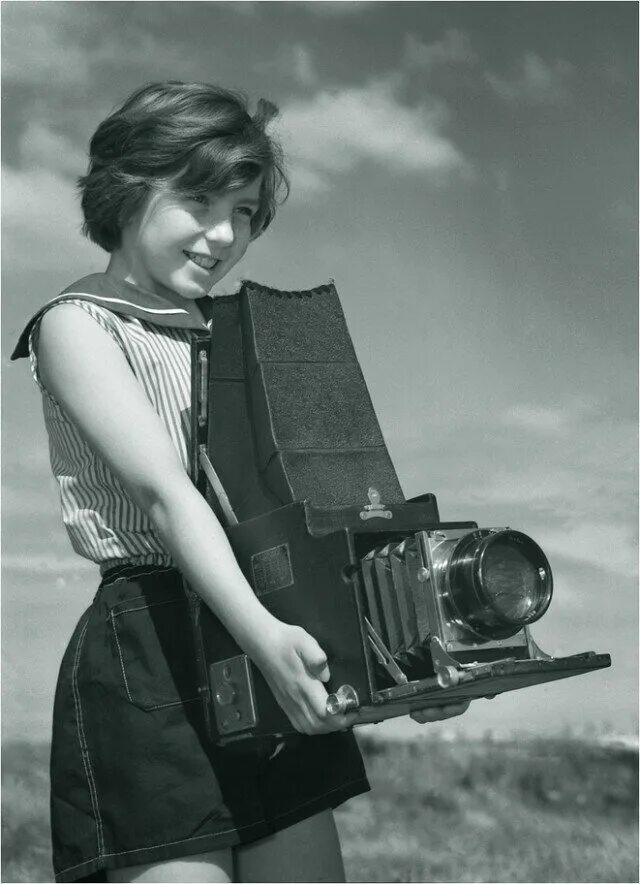Молодой старую на камеру. Старый фотоаппарат. Ретро фотограф. Девушка с фотоаппаратом.