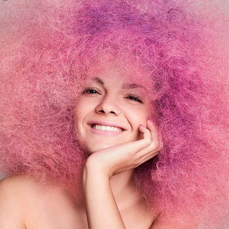 Девушка с указательным пальцем. Девушка улыбается вертикально. Самомассаж кожи головы. Девушка с красивой улыбкой показывает класс. Эмоция восторг.