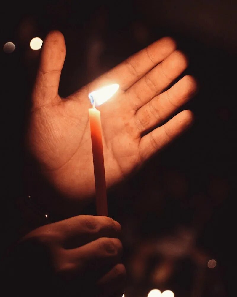 церковная свечка с бумажкой. свеча в руках. свечку держать надо. свечку держать надо. мужчина держит свечу.