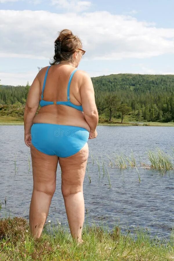 Упитанные женщины на реке. Толстая женщина в лифчике на природе.