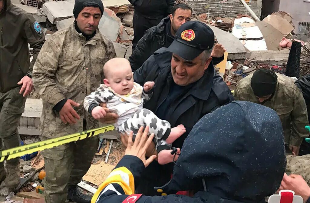 Мама обнимает ребенка под обломками крокус. Малыш из под завалов в Турции.