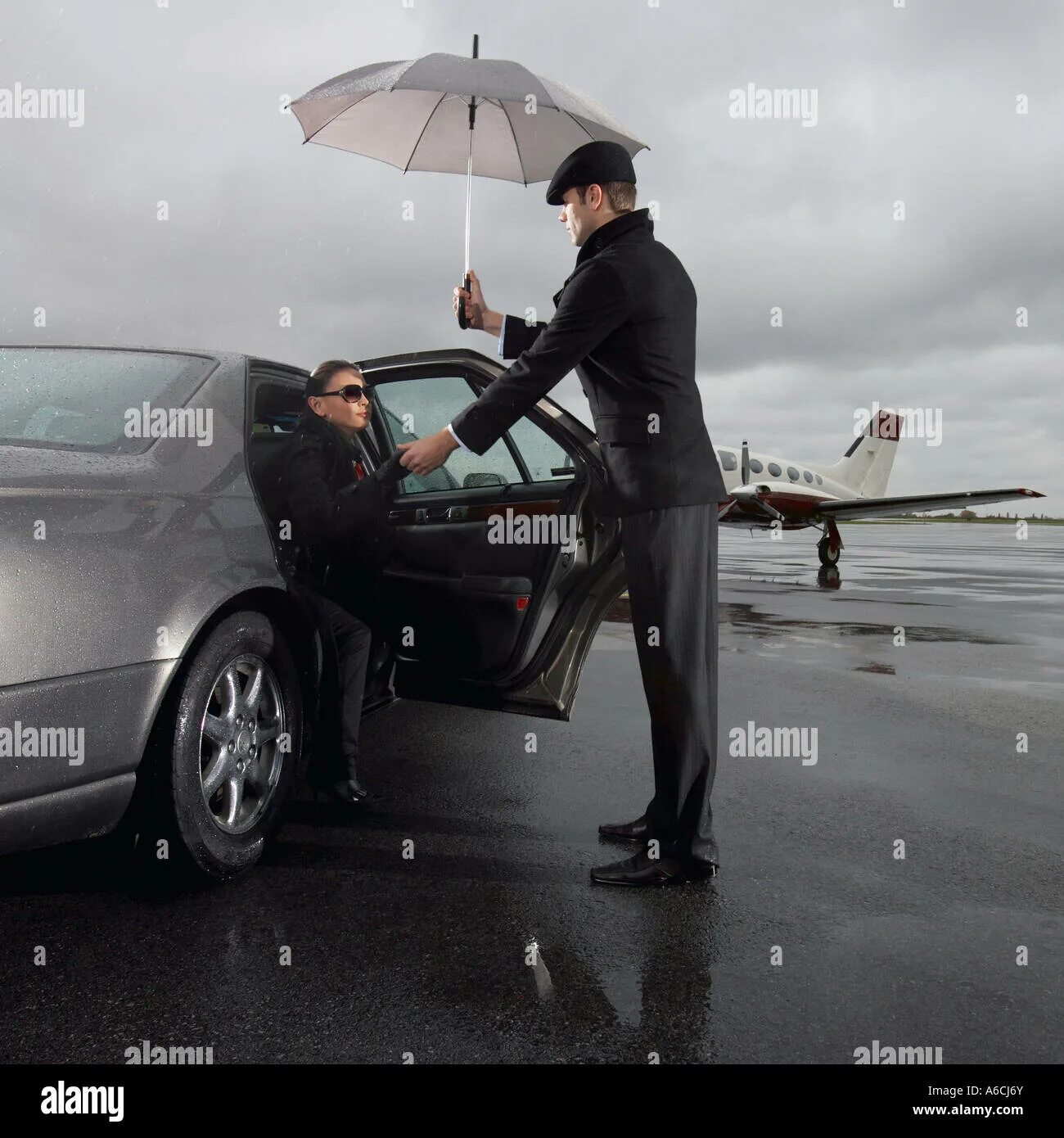 Зонт телохранителя. Мужчина выходит из машины. Мужчина подает руку женщине. Мужчина открывает дверь машины женщине.