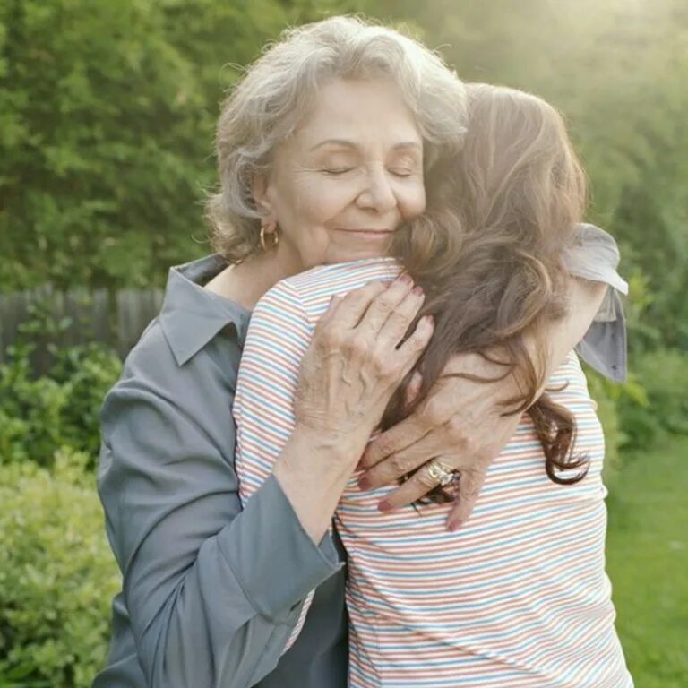 бабушка теплее мамы. бабушка обнимает. бабушка и взрослая внучка. молодая и пожилая женщина. пожилые люди.