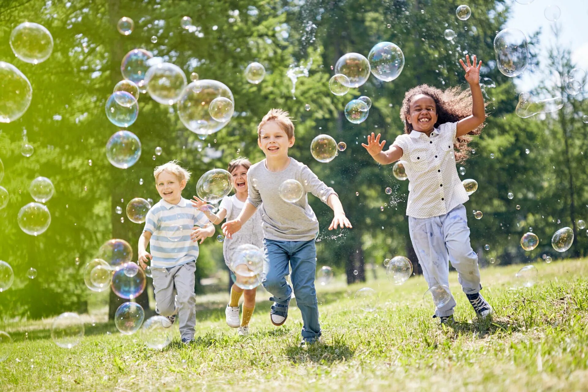 Развлечение детства. Дети и мыльные пузыри. Счастливый ребенок. Счастливые дети с мыльными пузырями. Радостные дети с мыльными пузырями.