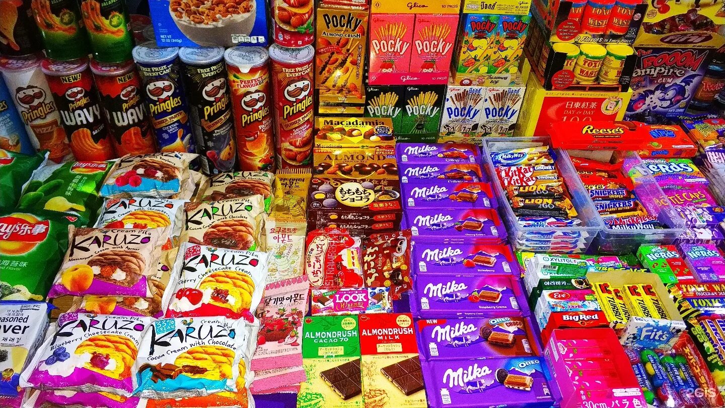 сладости магазинные. вкусняшки в магазине. красивая выкладка шоколада на витрине. сладкие продукты в магазине. выкладка бакалеи в магазине.