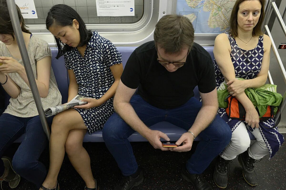 Человек сидит в метро. Мужчина сидит в метро. Мужчина сидит в общественном транспорте. Ноги в транспорте.