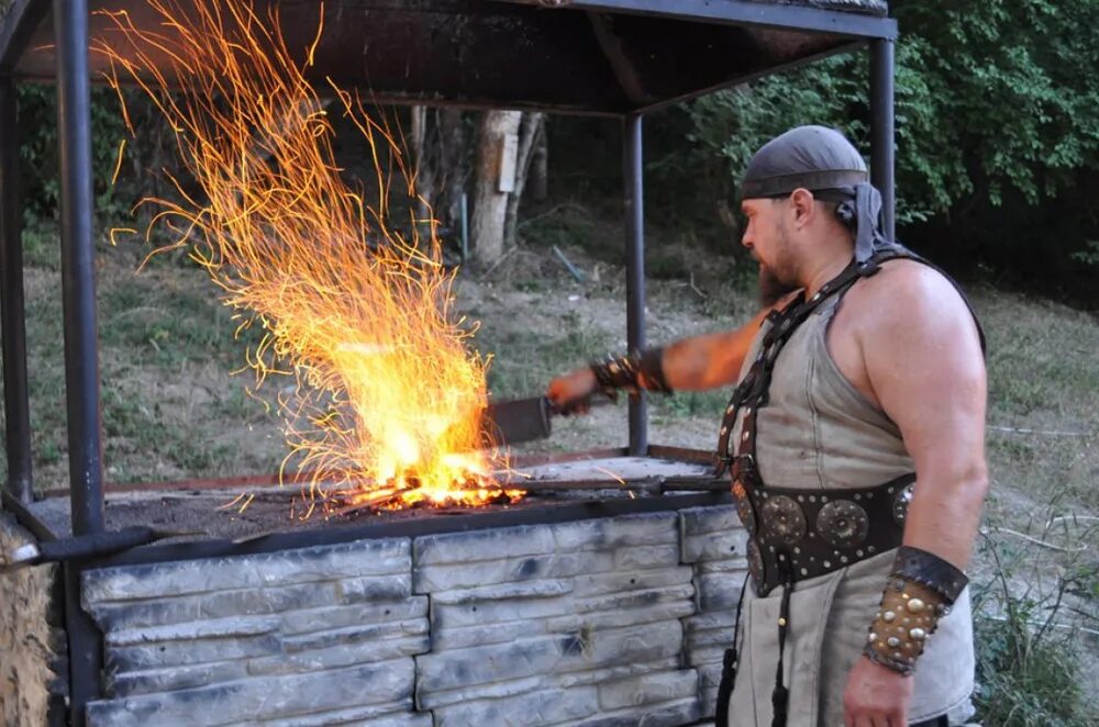 Стоять у горна. Стоять у горна. Кузница мастерская горынин. Кузнец в кузнице. Кузнец в кузнице.