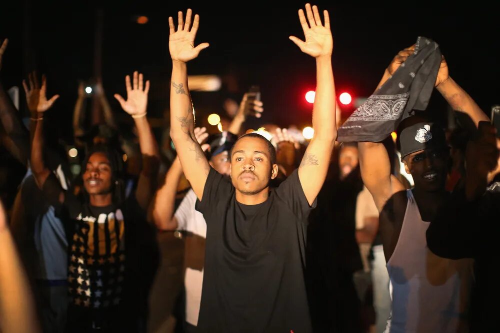 Don up high. Негр поднимает руки. Афроамериканец поднял руки. Руки вверх полиция. Преступник с поднятыми руками.