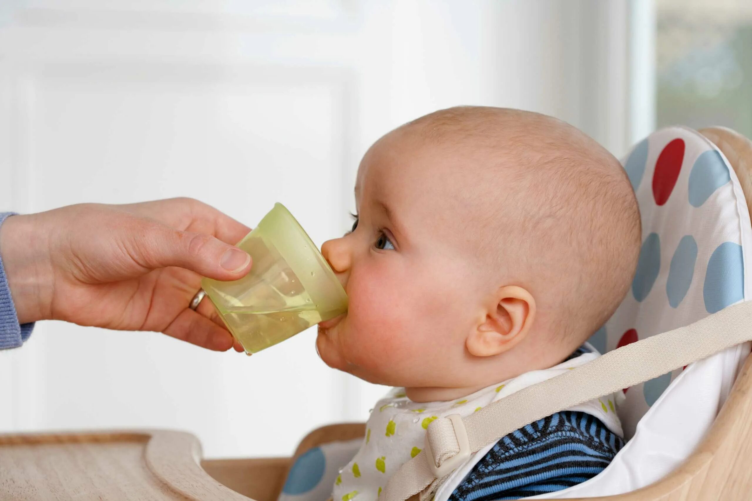 Докорм ребенка из чашки. Младенец пьет воду. Малыш пьет из чашки. Малыш пьет из кружки.