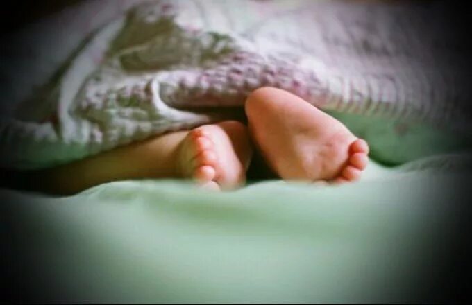 Детские ножки из под одеяла. Детские ножки в кроватке. Малыш выглядывает из под одеяла. Детские ноги под одеялом.