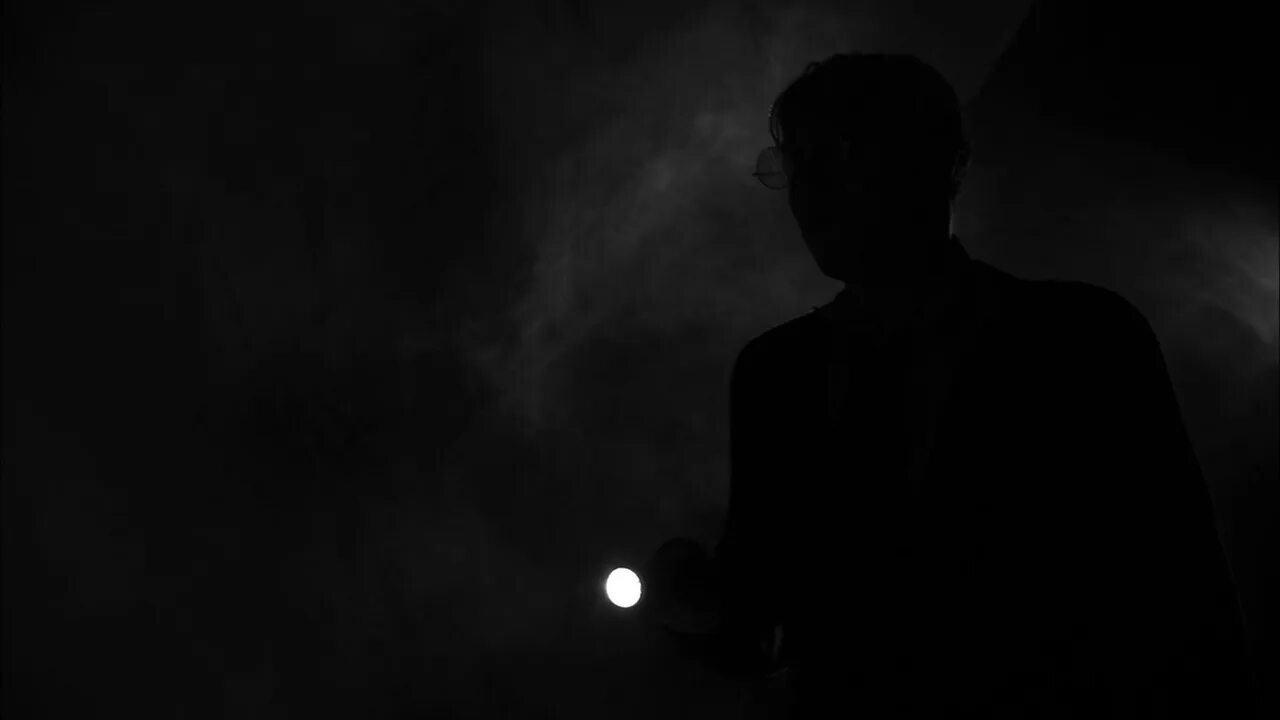 Фонарь во мраке. Светильник погаснет среди глубокой тьмы. Фонарный столб в темноте. Лампочки с мерцающим светом. Луч света во тьме.