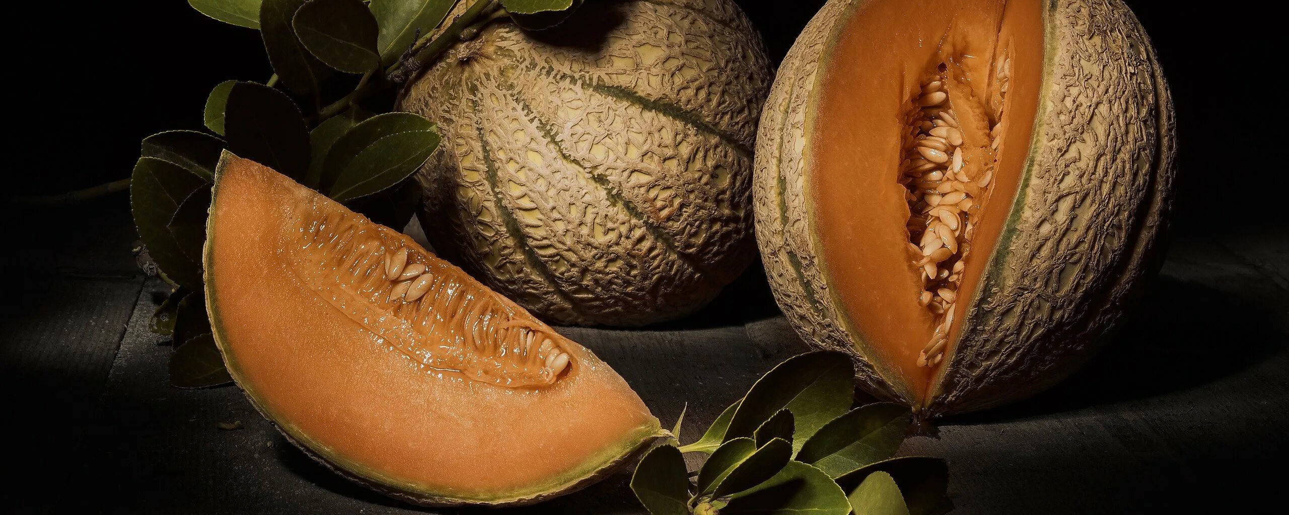 Дыня гранат. Дыня на черном фоне. дыня в разрезе. дыня сердцевина черная. сочная дыня на темном фоне.