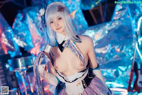 A woman in a blue and white outfit holding a microphone. 